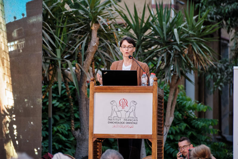 Dr Hana Navratilova at a lectern in front of palm trees