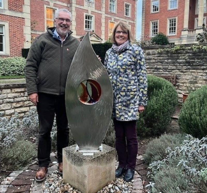 A man and a woman visiting the sculpture, 'Kindle', in the College quad. 