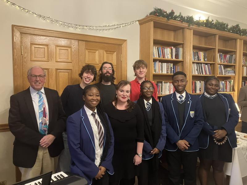 A group of nine people next to a keyboard