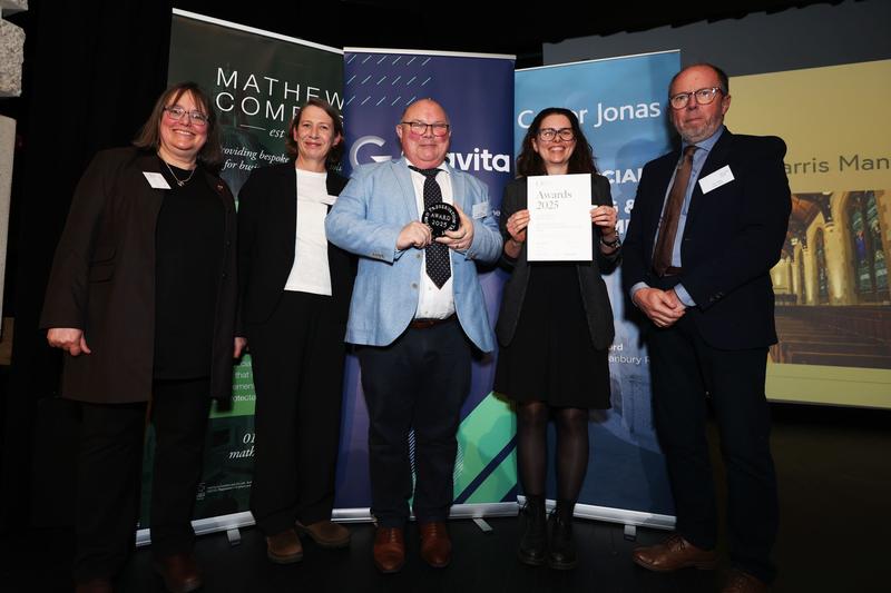 Five people in front of an awards display