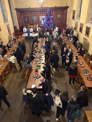 lots of people gathered in hall enjoying Christmas treats 