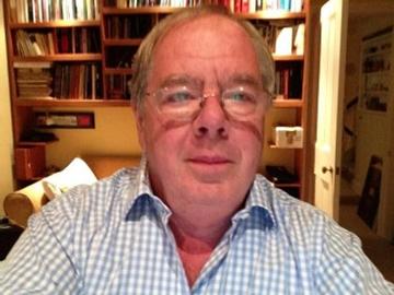 Headshot of a man with glasses in a checked shirt  