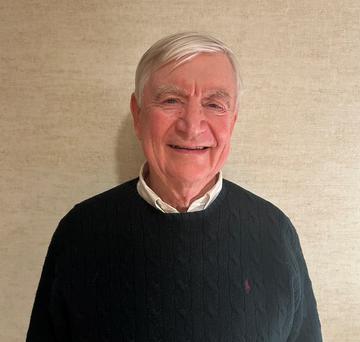 Headshot of a man in a green sweater