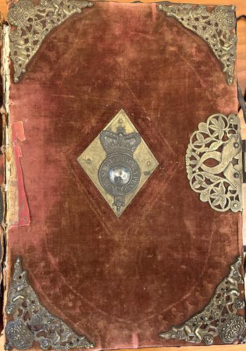 F15723 cover An elaborate cover with metal corners and central crest on a pink velvet background