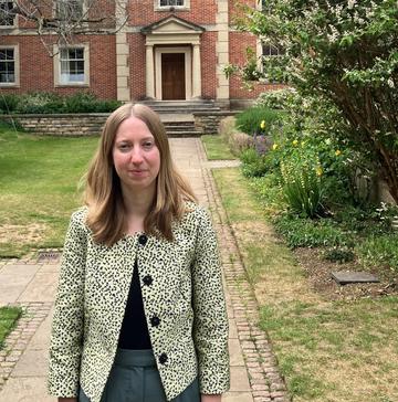 Woman standing in the college quad in front of buildings