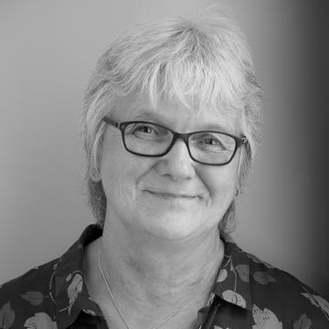 ​  Black and white photograph of a female.  Head and shoulders shot. 