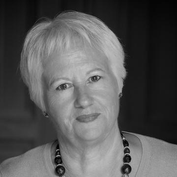 ​  Black and white photograph of a female.  Head and shoulders shot. 