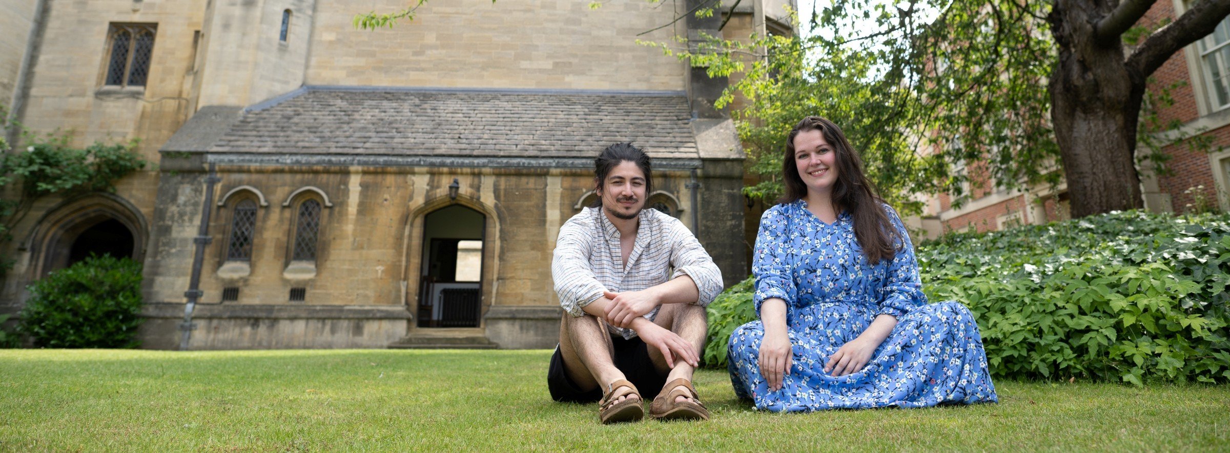 Two students sitting in the college quad