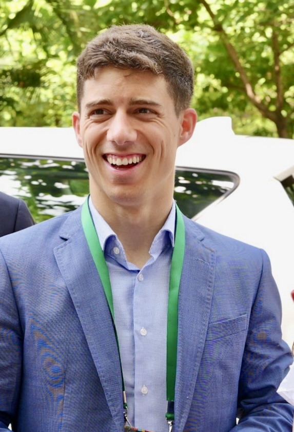 A young man in a suit against an indistinct background