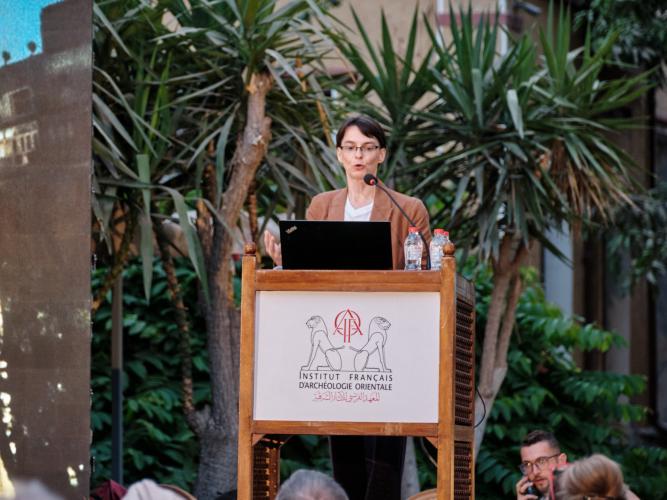 Dr Hana Navratilova at a lectern in front of palm trees