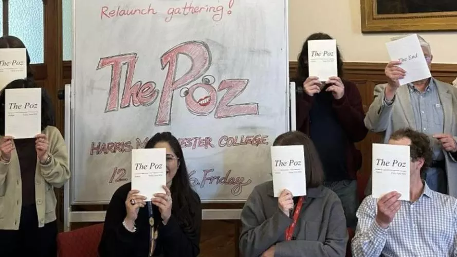 Contributors and supporters of 'The Poz' pose behind copies of the magazine, in recognition of contributors' anonymity