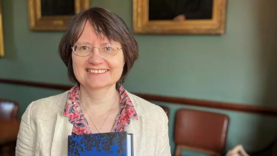Kate McLoughlin holding a copy of her book