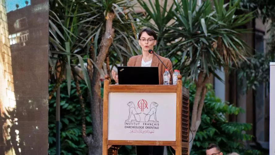 Dr Hana Navratilova at a lectern in front of palm trees