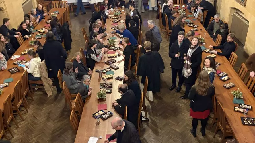 lots of people gathered in hall enjoying Christmas treats 