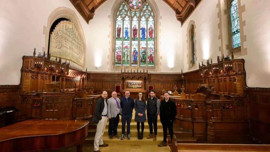 A group of people standing in the HMC Chapel