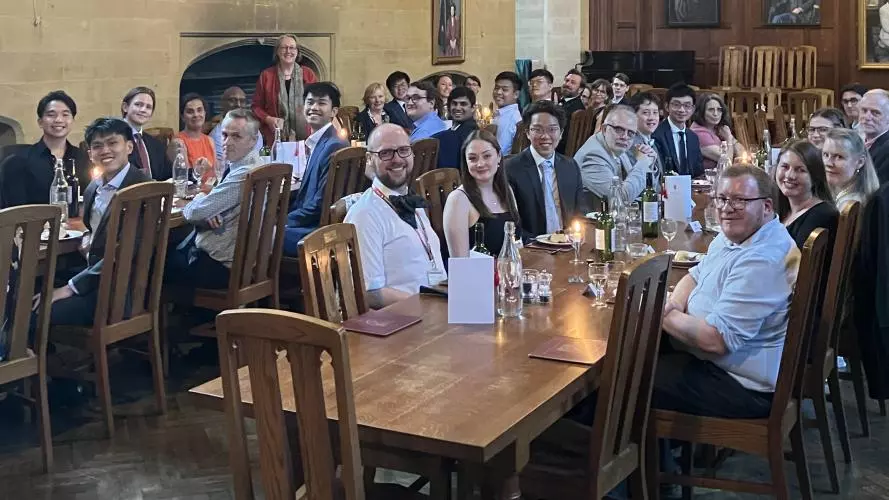 College hall with people seated at tables and smiling at camera