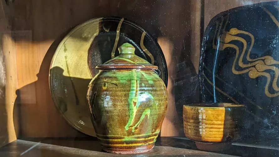 Pottery jar and plates in bright sunshire