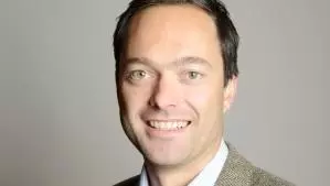 Professor Jan-Emmanuel de Neve, former Vice-Principal of HMC, posing in front of a grey background.