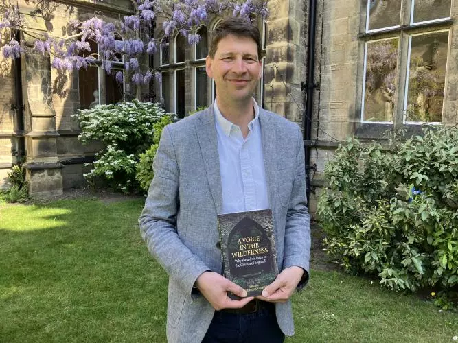 Professor Joshua Hordern holding book