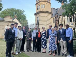 A group of people pose for the camera in front of a clock tower