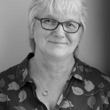 ​  Black and white photograph of a female.  Head and shoulders shot. 
