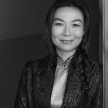 ​  Black and white photograph of a female.  Head and shoulders shot. 