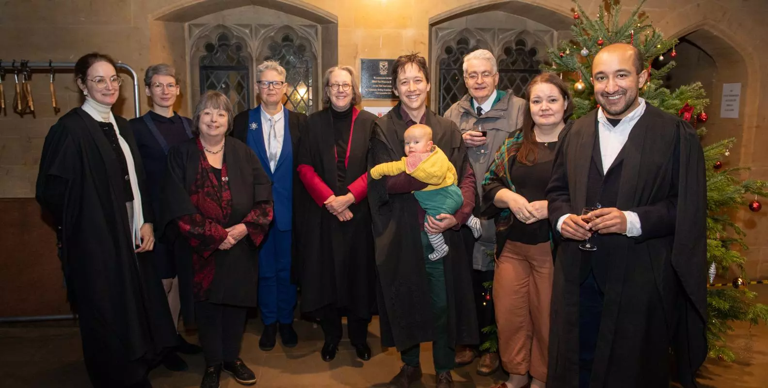 Members of Harris Manchester Alumni, pictured with Professor Jane Shaw next to a Christmas tree.