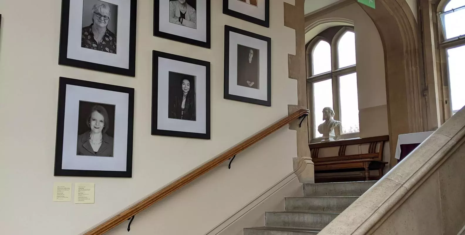 Mounted portraits of the Women Who Made (Harris) Manchester College on the stairs