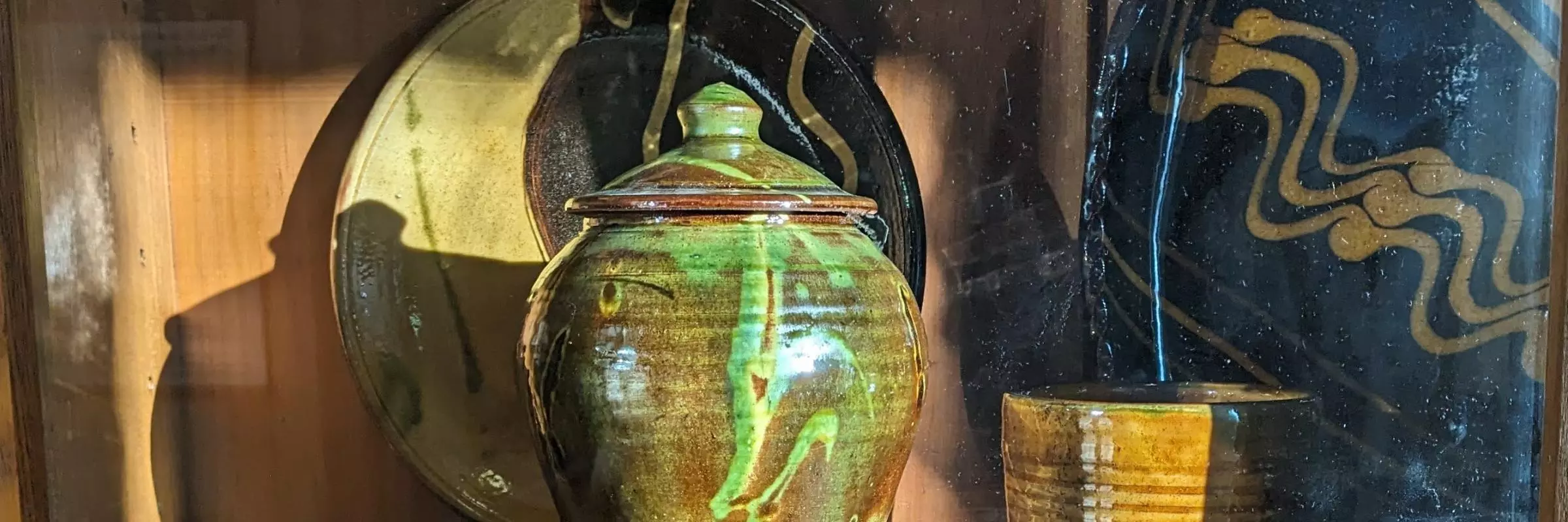 Pottery jar and plates in bright sunshire