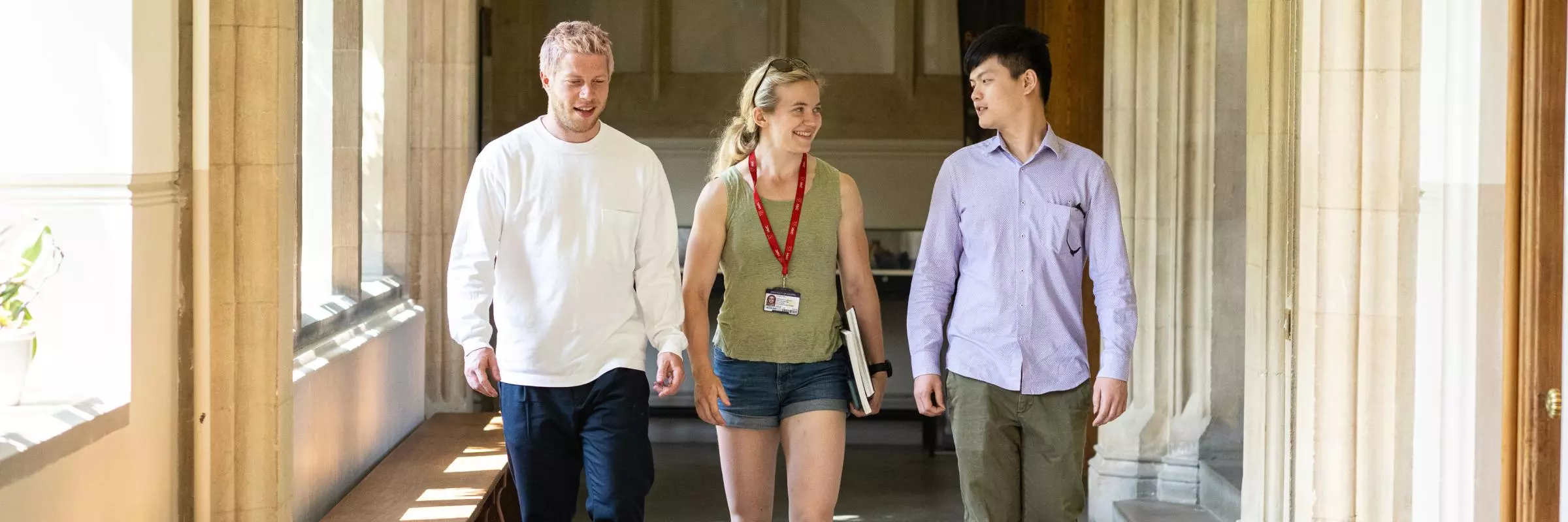 Two men and a woman walking down corridor