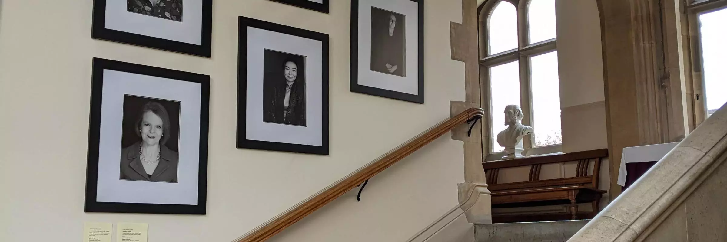 Mounted portraits of the Women Who Made (Harris) Manchester College on the stairs
